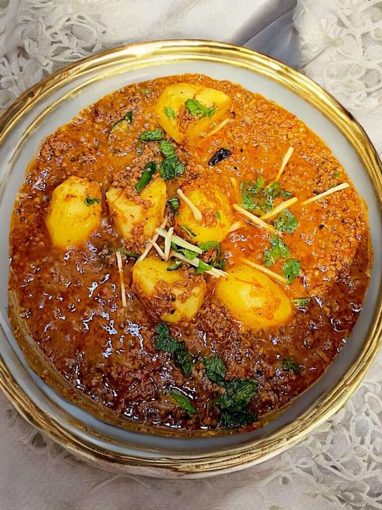 aloo keema arranged in white bowl on neutral linen