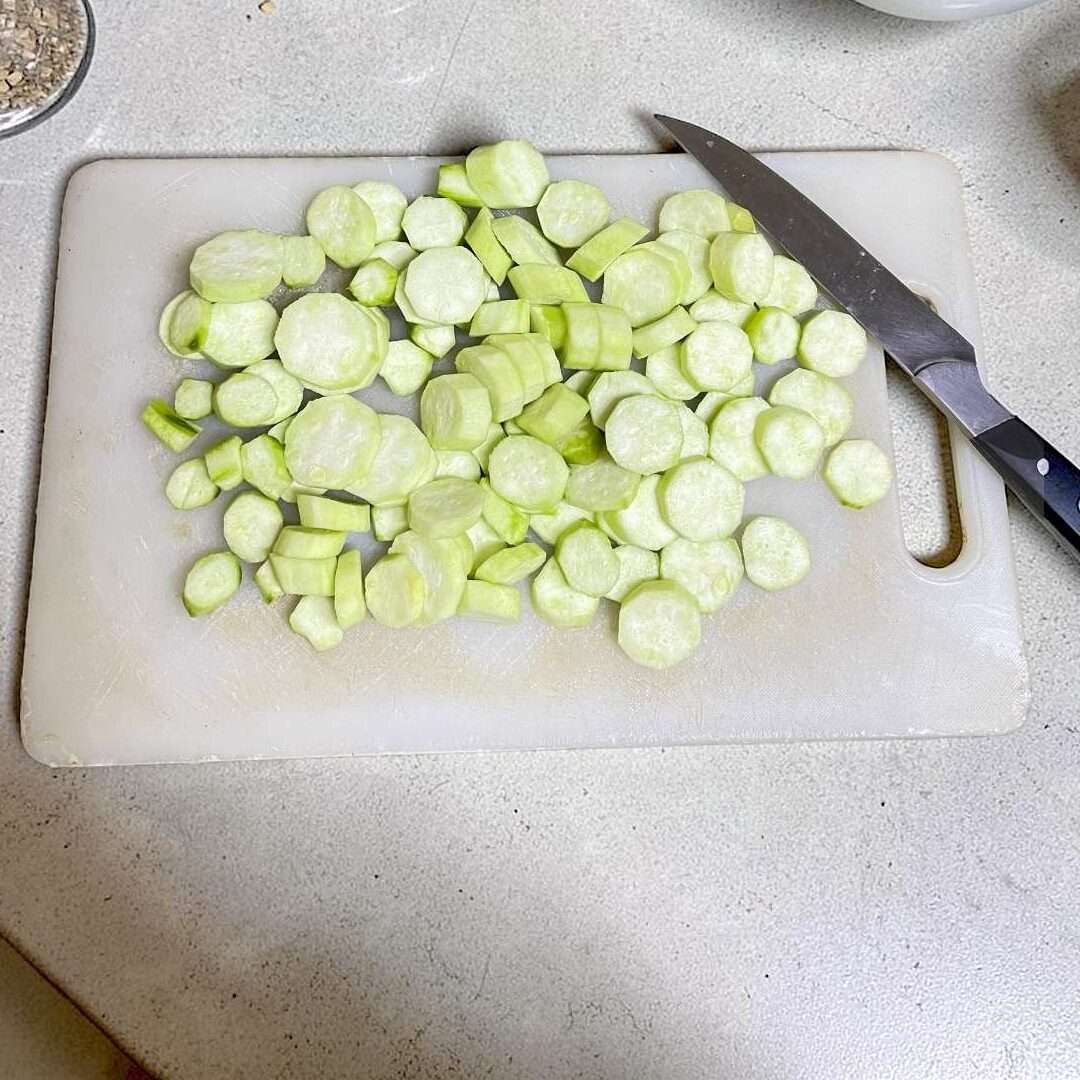 ridge gourd cut into round medium size shape, arranged on cutting board, placed on kitchen counter.