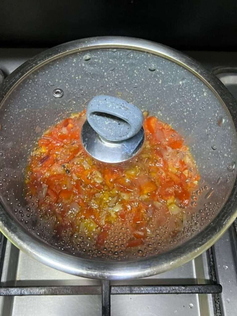 Tomatoes cooking until soft and mushy.