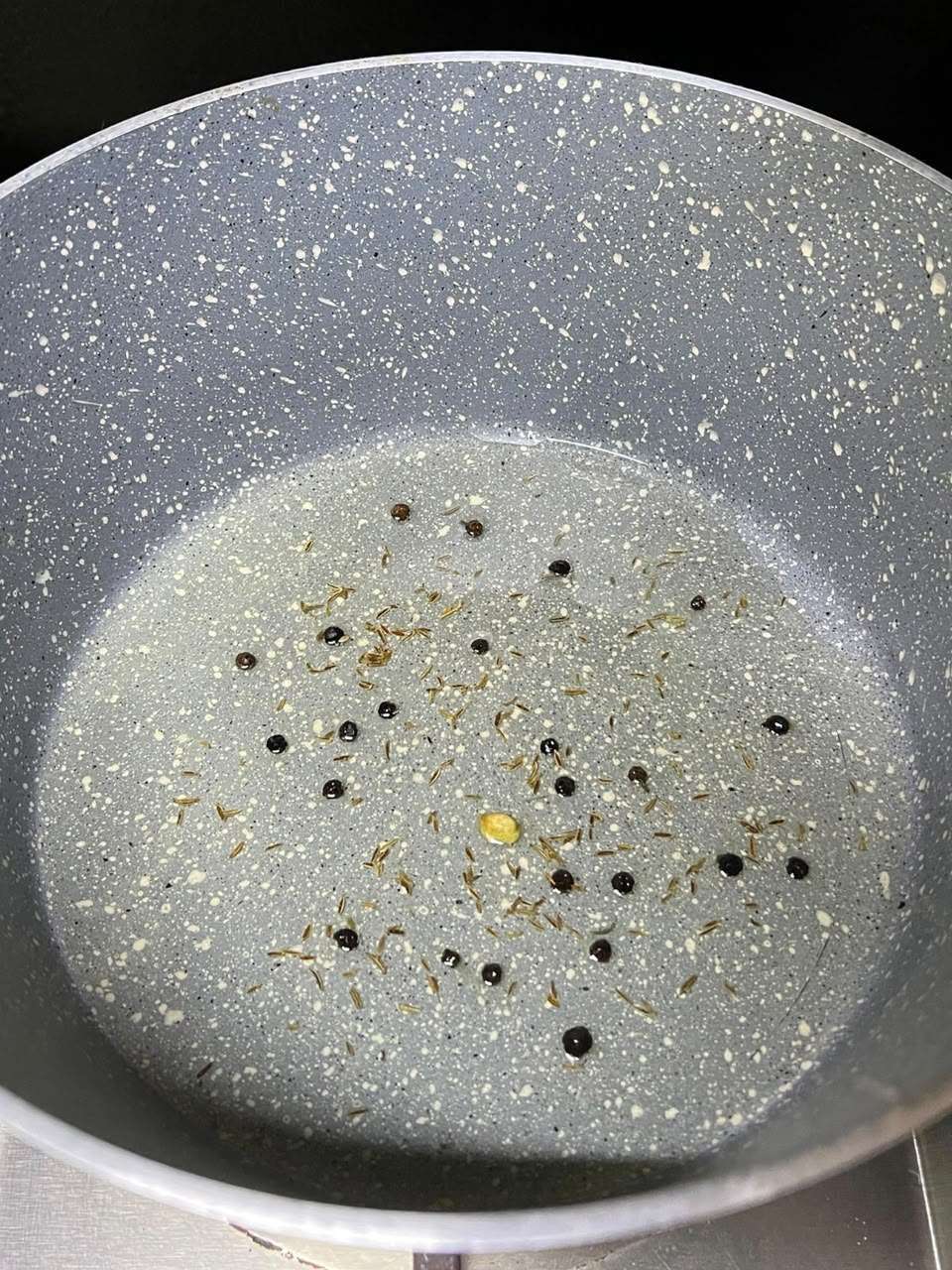 Whole spices sizzling in hot oil.
