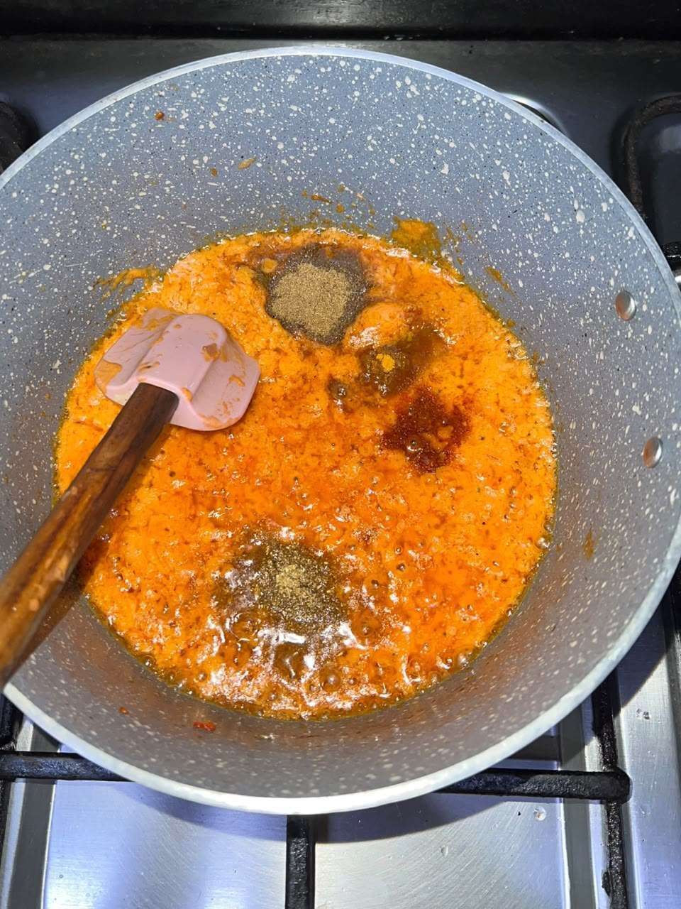 Ground spices added to the onion-tomato mixture.