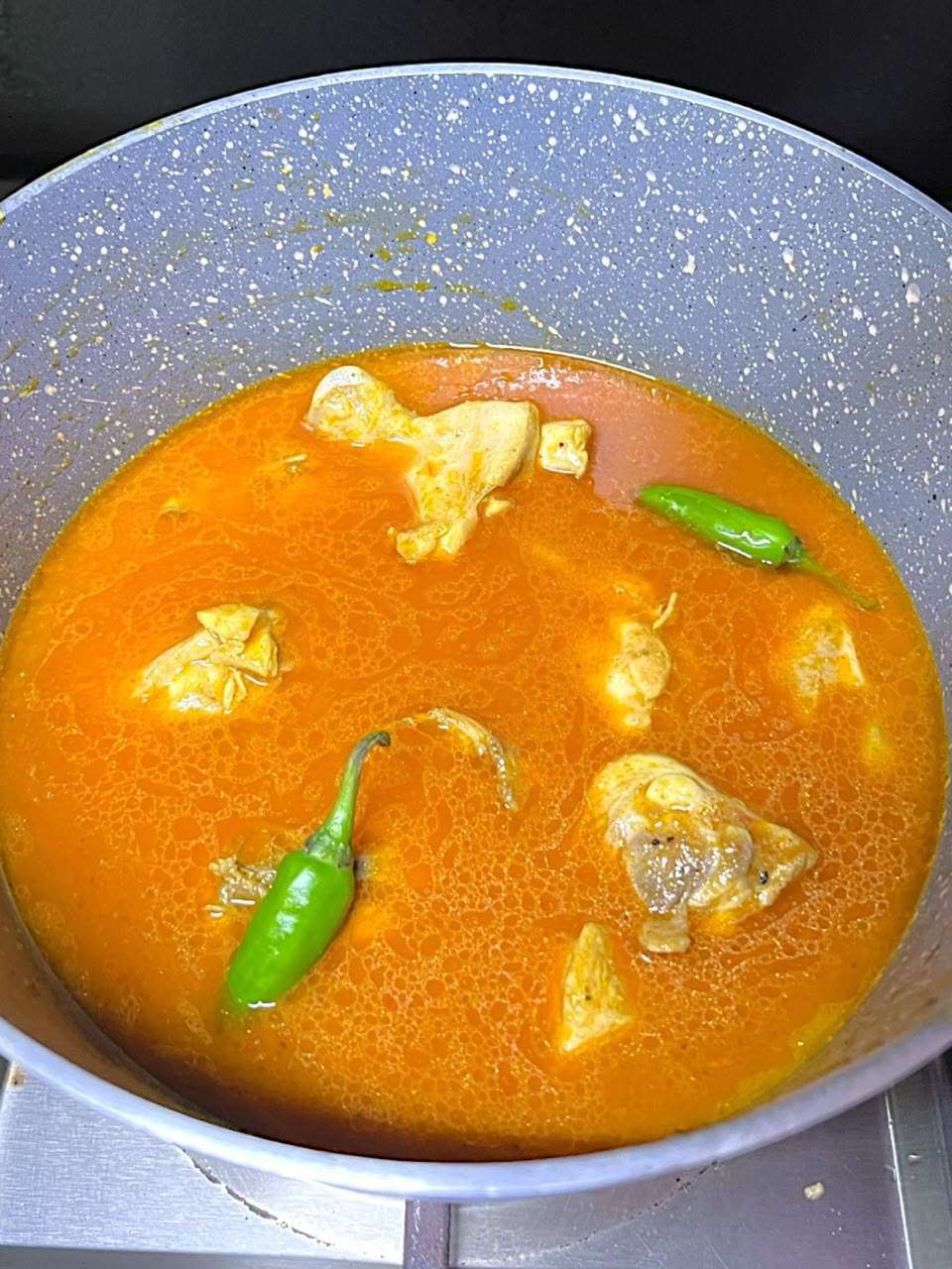water and green chillies are added to the chicken masala.