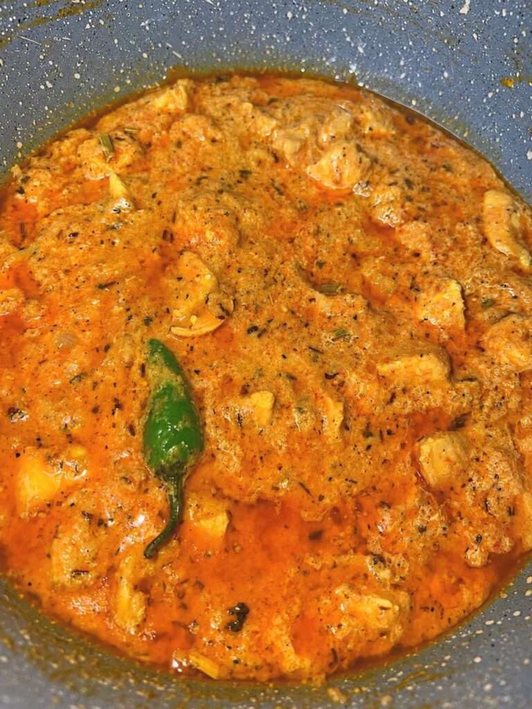 Creamy chicken handi simmering with green chili
