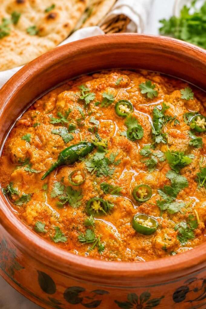 Creamy chicken handi served in a traditional clay pot