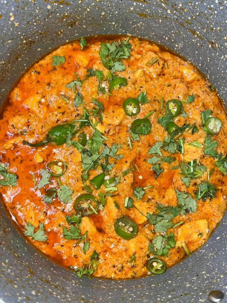 Chicken handi garnished with cilantro and green chilies