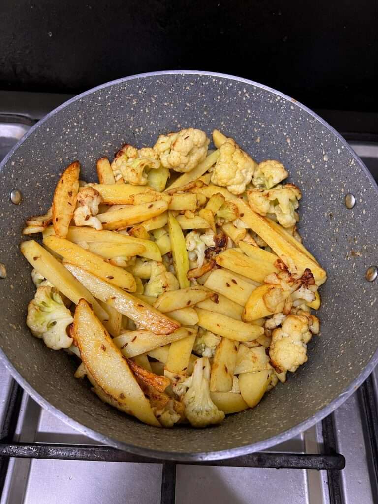 Golden fried potatoes and cauliflower in a pan