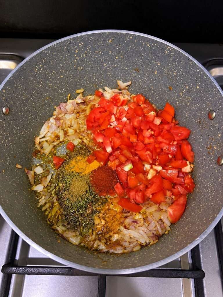 Chopped tomatoes and spices added to fried onions