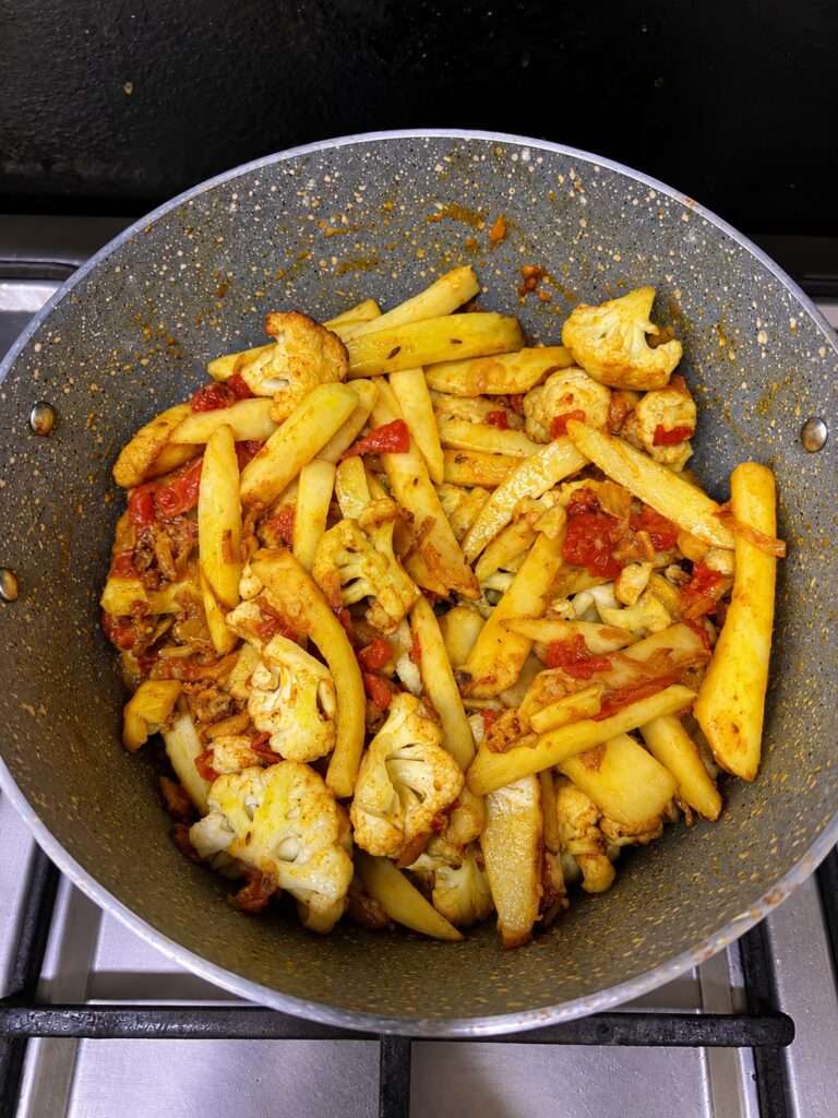 Fried potatoes and cauliflower mixed with tomato masala