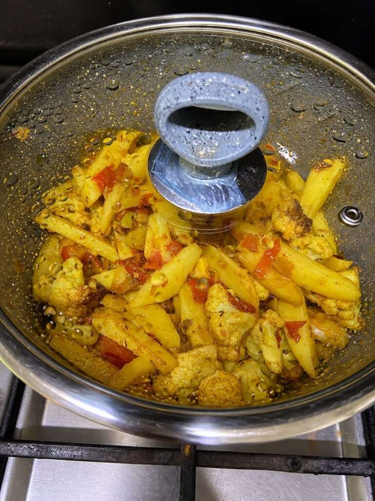 Aloo Gobi cooking covered in a pan